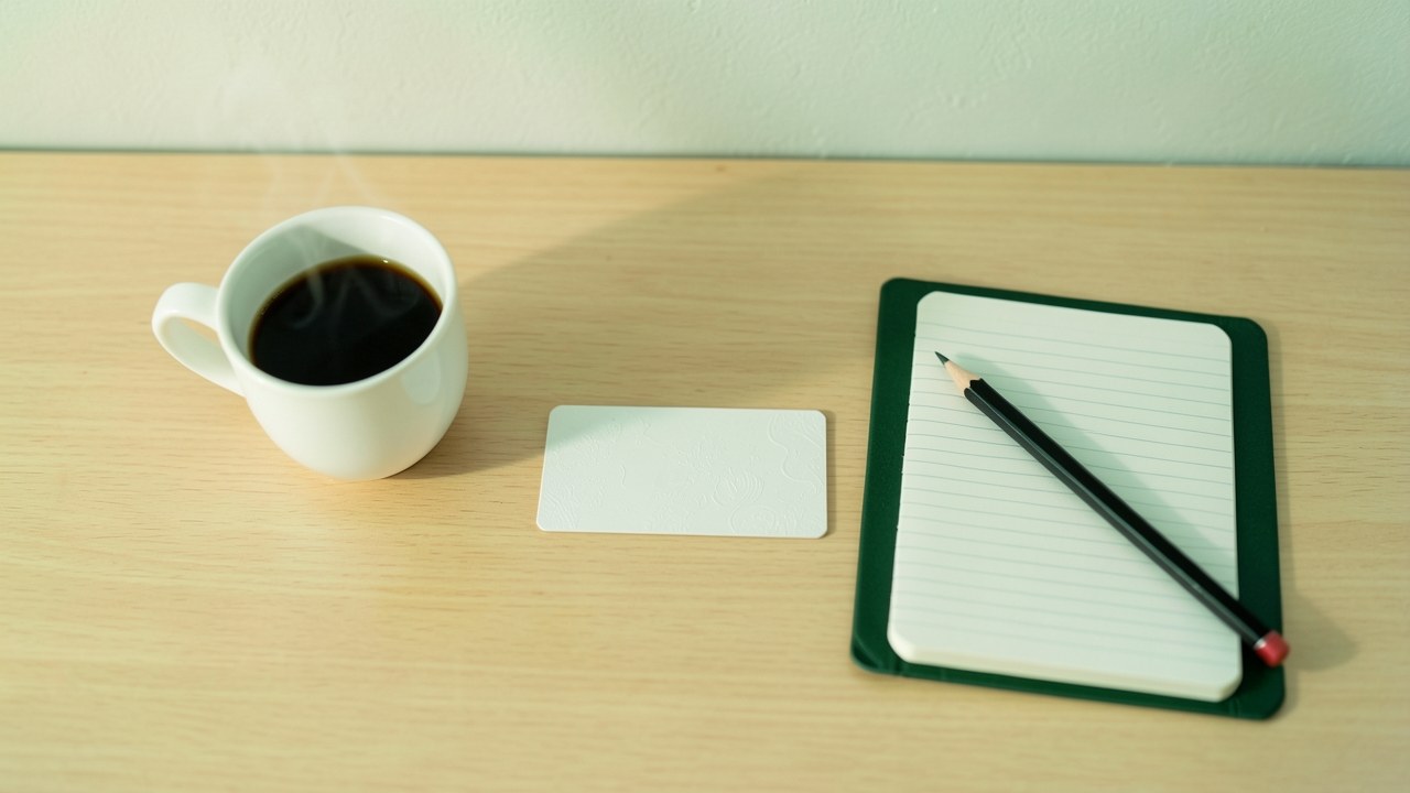 A clean desk scene with a credit card, a small notebook, and a pencil, in warm natural light, conveying a sense of careful planning.